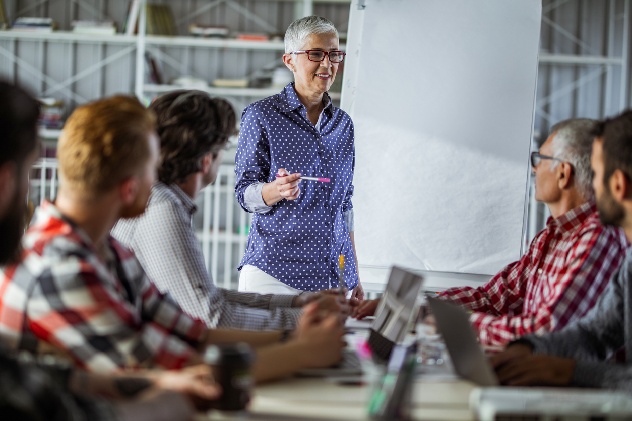 Happy-female-business-leader-having-a-meeting-with-her-male-team-in-the-office.-1091698116_1258x838